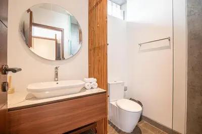 a bathroom with a sink and a toilet and a mirror at Stunning 5BR Canggu Villa 400m from the Beach in Canggu