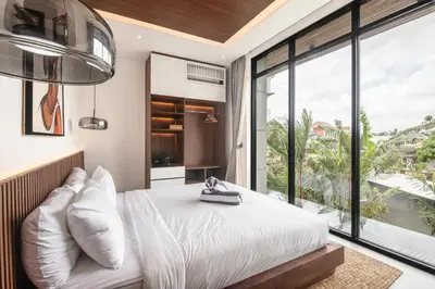 a bedroom with a bed and a large window at Luxury 5-Bedroom Oasis 400 m to Canggu Sand in Canggu