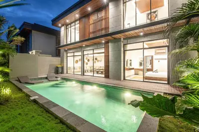 a swimming pool in front of a house at Luxury 5-Bedroom Oasis 400 m to Canggu Sand in Canggu