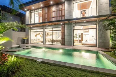 a swimming pool in front of a house at Luxury 5-Bedroom Oasis 400 m to Canggu Sand in Canggu