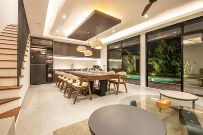 an open kitchen and dining room with a table and chairs at Luxury 5-Bedroom Oasis 400 m to Canggu Sand in Canggu