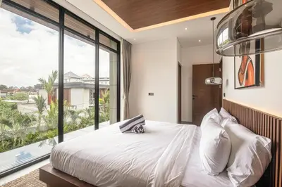 a bedroom with a white bed and a large window at Luxury 5-Bedroom Oasis 400 m to Canggu Sand in Canggu