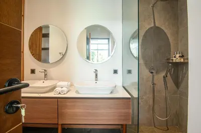 a bathroom with two sinks and two mirrors at Serene 5-Bedroom Villa 400 m from Batu Bolong in Canggu