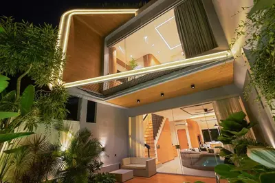 a house with a large window with a living room at Modern 2BR Design Haven with green views, rooftop in Kerobokan
