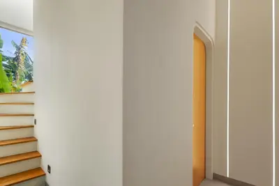 a hallway with white walls and a stair case at Modern 2BR Design Haven with green views, rooftop in Kerobokan