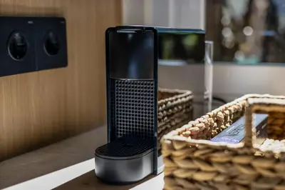 a black appliance sitting on a table next to a basket at Modern 2BR Design Haven with green views, rooftop in Kerobokan