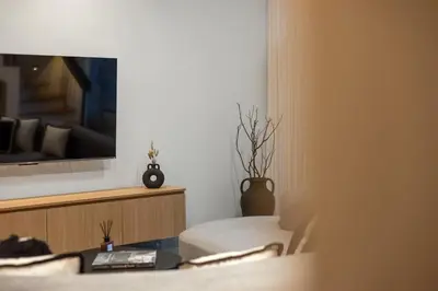 a room with a bed and a tv on a wall at Contemporary 2BR Luxury Villa with Rooftop View and Pool in Kerobokan