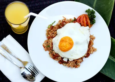 a plate of food with a fried egg on top at Srikandi Inn in Jimbaran