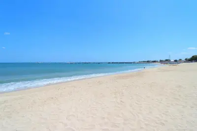 a sandy beach with the ocean in the background at Srikandi Inn in Jimbaran