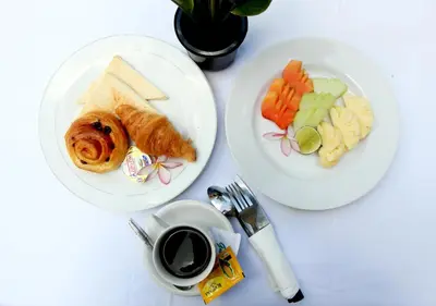 two white plates of food and a cup of coffee at Srikandi Inn in Jimbaran