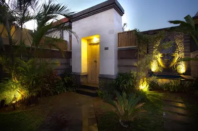 a front door of a house with a mask on it at Kayu Suar Bali Luxury Villas & Spa in Sanur
