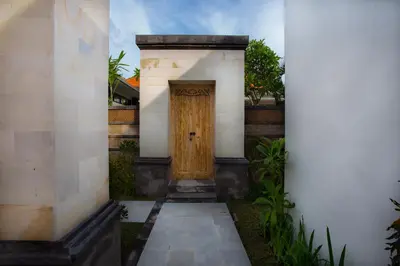 a wooden door on the side of a building at Kayu Suar Bali Luxury Villas & Spa in Sanur