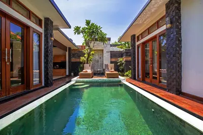 an infinity pool in the backyard of a villa at Kayu Suar Bali Luxury Villas & Spa in Sanur