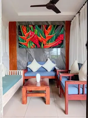 a living room with a couch and a painting on the wall at Casa Green Kori in Kerobokan