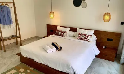 a bedroom with a large white bed with towels on it at Chic Villa at Kubu Taullan 3B in Kerobokan