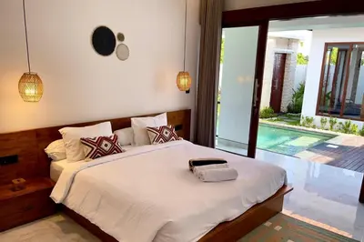 a bedroom with a large bed and a pool at Chic Villa at Kubu Taullan 3B in Kerobokan