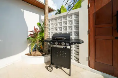 a black grill in a room with a door at New Luxury 3BR Villa walk to Atlas, Finns & Berawa beach in Canggu