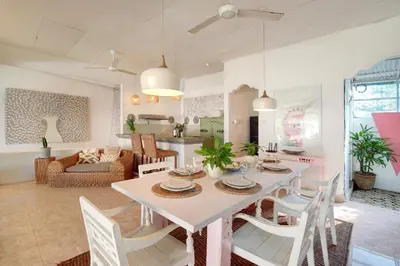 a dining room and living room with a table and chairs at Villa Bohème Umalas in Canggu
