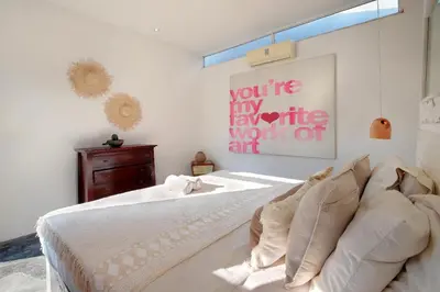 a bedroom with a bed and a painting on the wall at Villa Bohème Umalas in Canggu