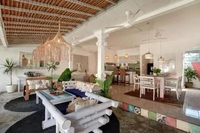 a living room with a couch and a dining room at Villa Bohème Umalas in Canggu
