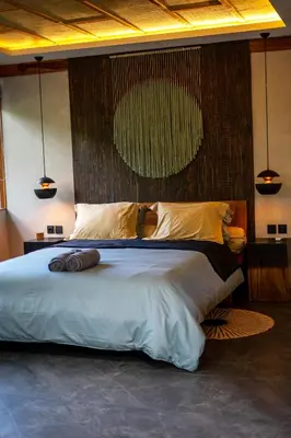 a bedroom with a large bed with two pillows at Kayunida - Charming 1BR Wooden Villa in Seminyak in Seminyak