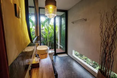 a bathroom with a toilet and a large window at Kayunida - Charming 1BR Wooden Villa in Seminyak in Seminyak