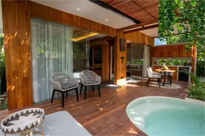 a hot tub on a deck with chairs and a table at Kayunida - Charming 1BR Wooden Villa in Seminyak in Seminyak
