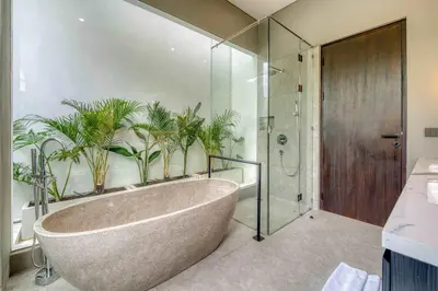 a bathroom with a tub with plants on the wall at Rooftop Villa Elegant 4BR Retreat in Umalas in Kerobokan