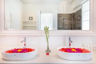 two sinks with flowers in them on a bathroom counter at Villa Shankara 1 in Canggu