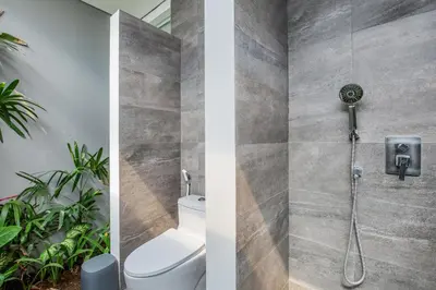 a bathroom with a shower with a toilet and plants at Villa Shankara 1 in Canggu
