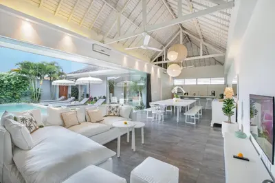 a living room with white couches and a dining room at Villa Shankara 1 in Canggu