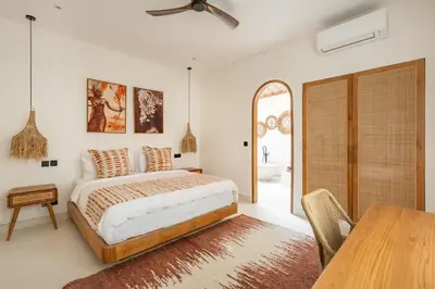 a bedroom with a bed and a dining table at Villa Nusa in Canggu