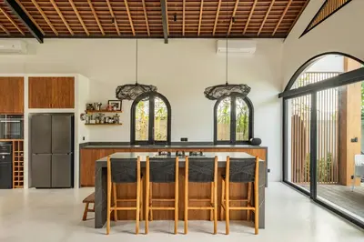 an open kitchen with a table and chairs at Villa Nusa in Canggu