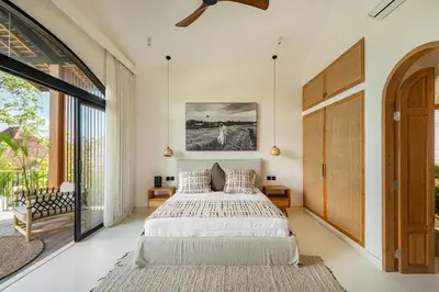 a bedroom with a bed and a large window at Villa Nusa in Canggu
