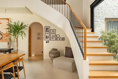 a staircase in a living room with a table and chairs at Villa Nusa in Canggu