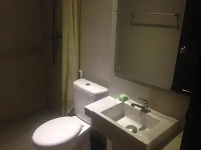 a bathroom with a white toilet and a sink at Pondok Sutya in Kuta
