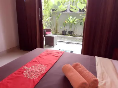 two towels on top of a bed in a room at Pondok Sutya in Kuta