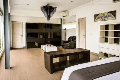 a bedroom with a bed and a living room at Villa Avrora Batubelig in Canggu