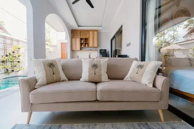 a couch sitting in a living room next to a bed at Arjuna Villa in Seminyak