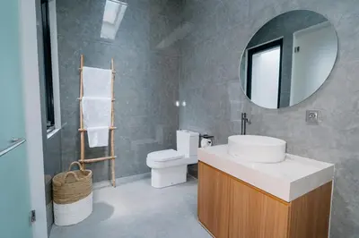 a bathroom with a sink and a toilet and a mirror at Arjuna Villa in Seminyak
