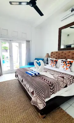 two beds in a bedroom with a mirror at Villa Umah JD Umalas 3 kamar private pool in Canggu