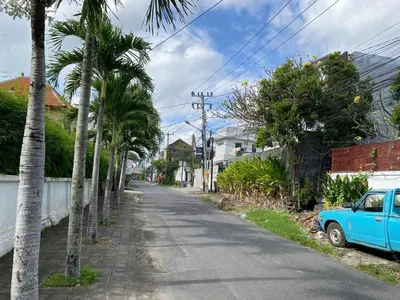 a blue car parked on the side of a street with palm trees at Villa Umah JD Umalas 3 kamar private pool in Canggu