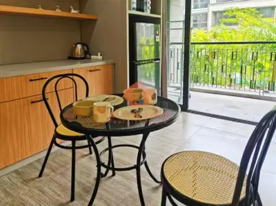 a table with two chairs and a table with cups and plates at Lavaya Resort 1BR Nusa Dua Pool, WiFi, Netflix in Nusa Dua