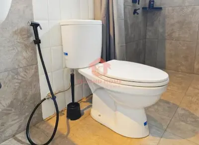 a white toilet in a bathroom with a hose at Lavaya Resort 1BR Nusa Dua Pool, WiFi, Netflix in Nusa Dua