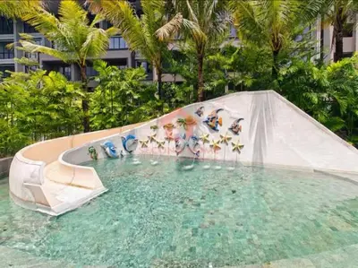 a group of people on a water slide in a pool at Lavaya Resort 1BR Nusa Dua Pool, WiFi, Netflix in Nusa Dua