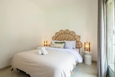 a bedroom with a large white bed with two pillows at Homey Villa 2BR Seminyak in Seminyak