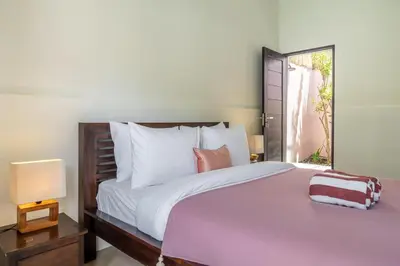 a bedroom with a large bed and a window at Homey Villa 2BR Seminyak in Seminyak
