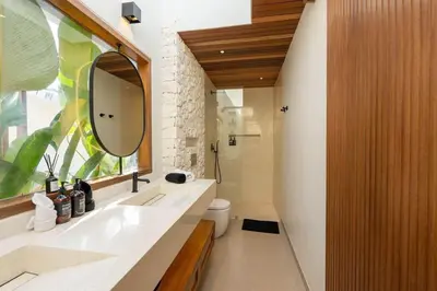a bathroom with a sink and a mirror and a toilet at 2BR Modern Mediterranean Villa Near Nook in Badung