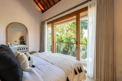 a bedroom with a large bed and a large window at 2BR Modern Mediterranean Villa Near Nook in Badung