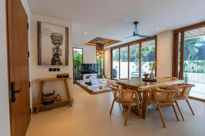 a dining room with a wooden table and chairs at 2BR Modern Mediterranean Villa Near Nook in Badung